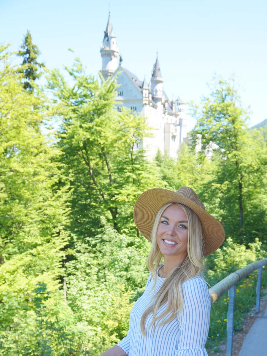 Blond girl smiling on path Tegelbergbahn with castle in background